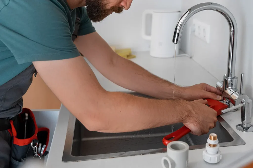 Fontanero reparando el grifo de un fregadero de cocina
