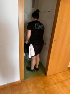 Profesional de limpieza trabajando en el pasillo de una vivienda